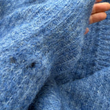 Close-up of sleeve detailing on the cobalt blue Skyline cardigan, subtle distressed finish