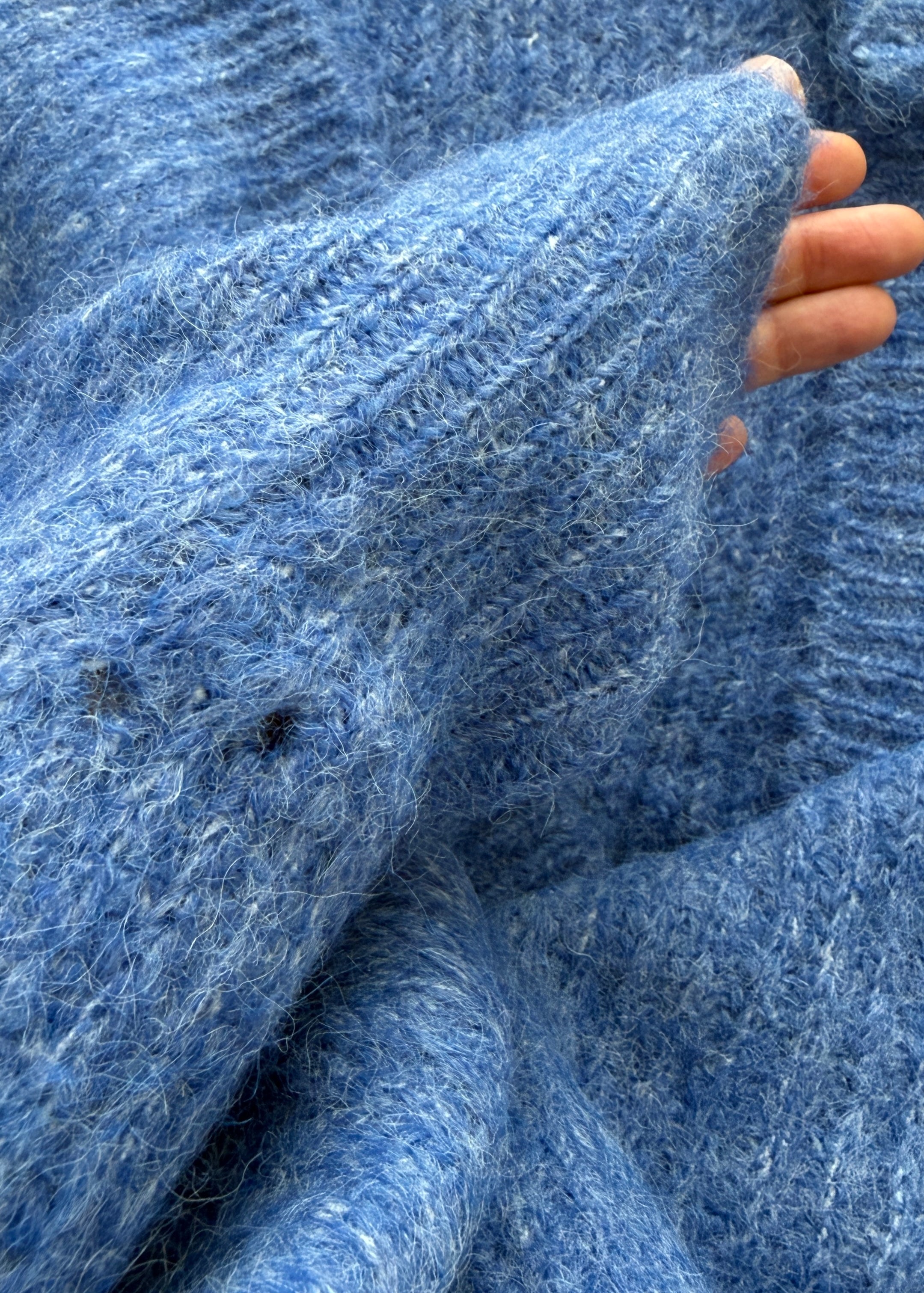 Close-up of sleeve detailing on the cobalt blue Skyline cardigan, subtle distressed finish
