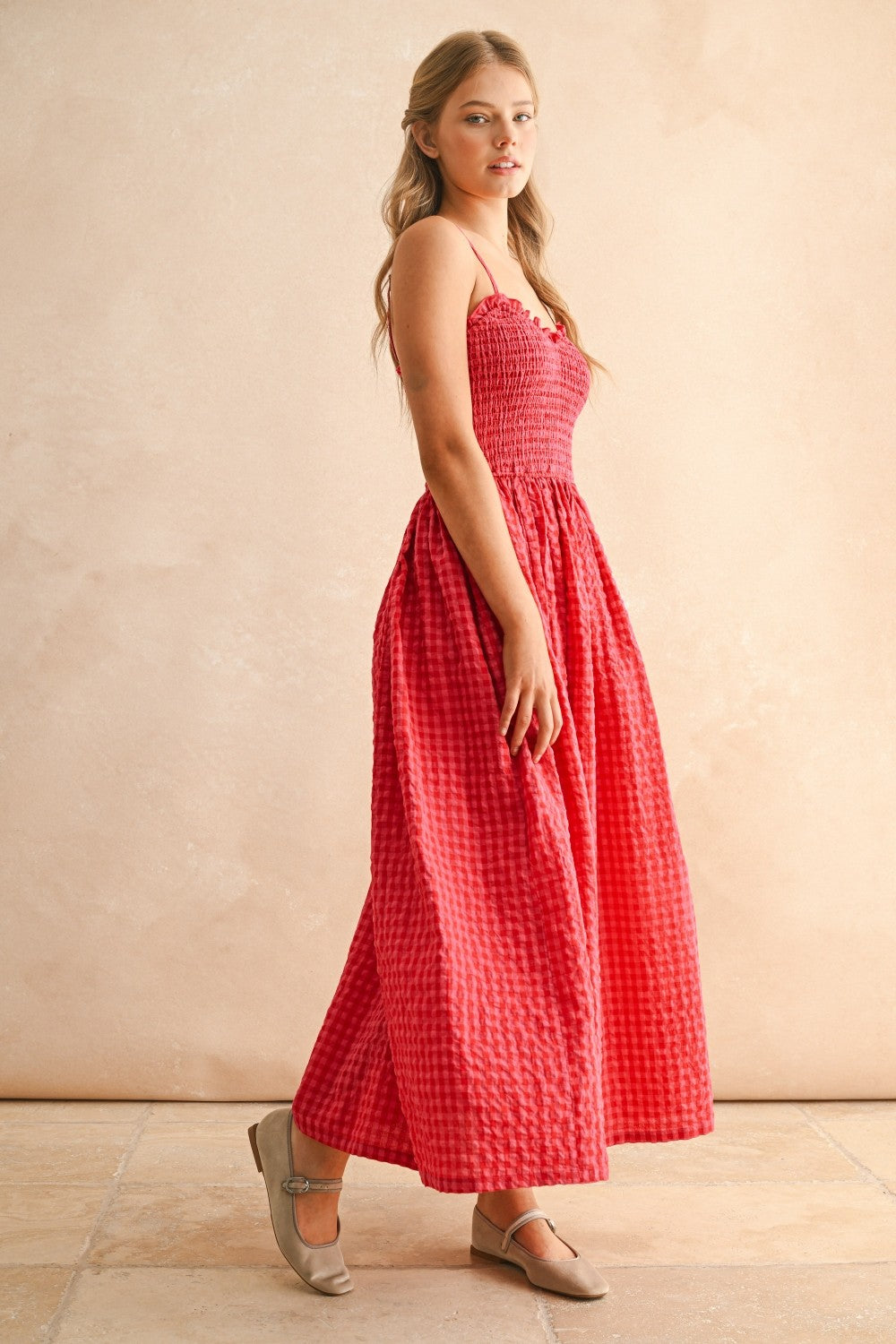 Side view of cherry gingham cotton maxi dress with smocked bodice
