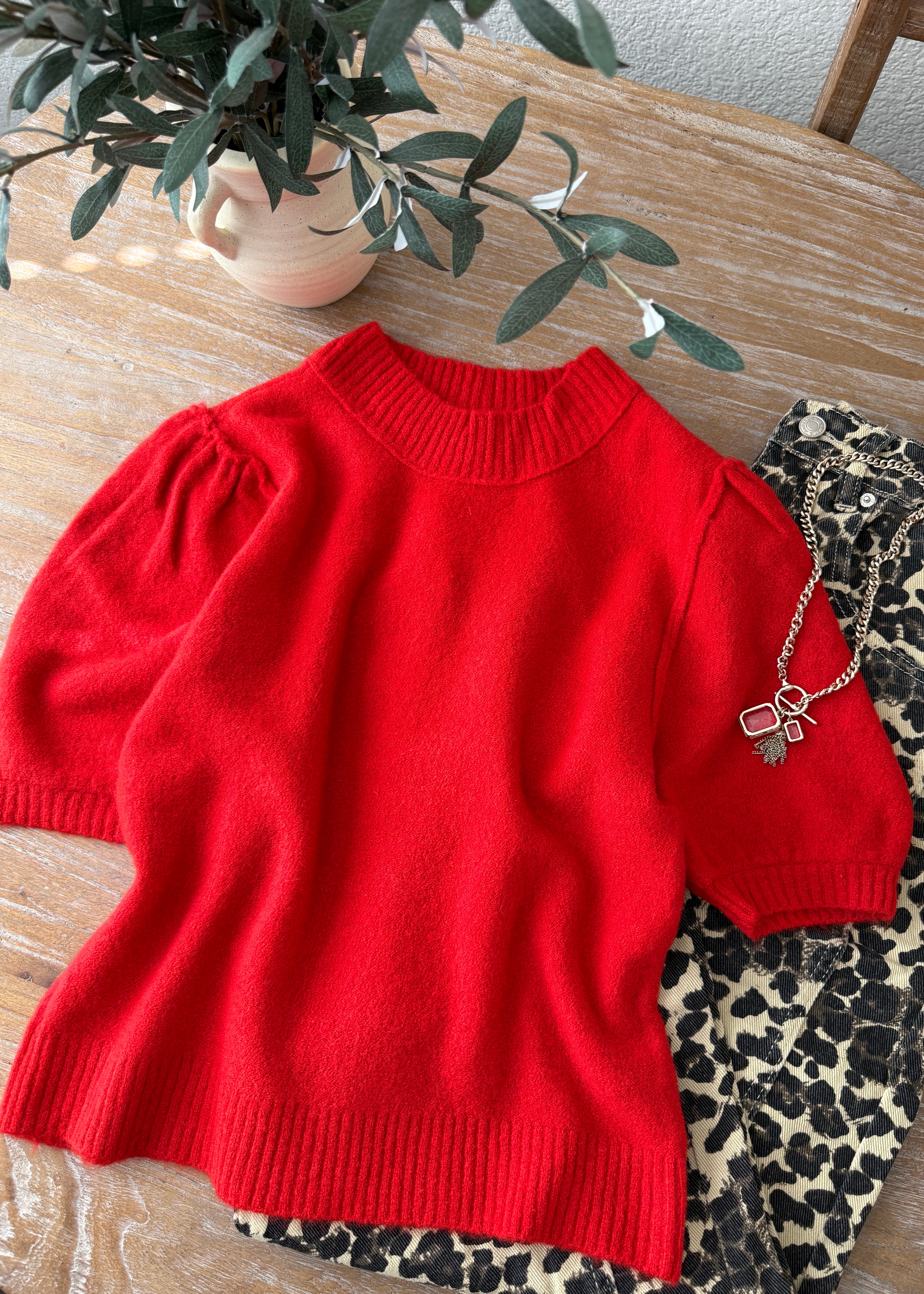 flat lay of the red balloon sleeve short sleeve sweater highlighting the crew neckline and hem