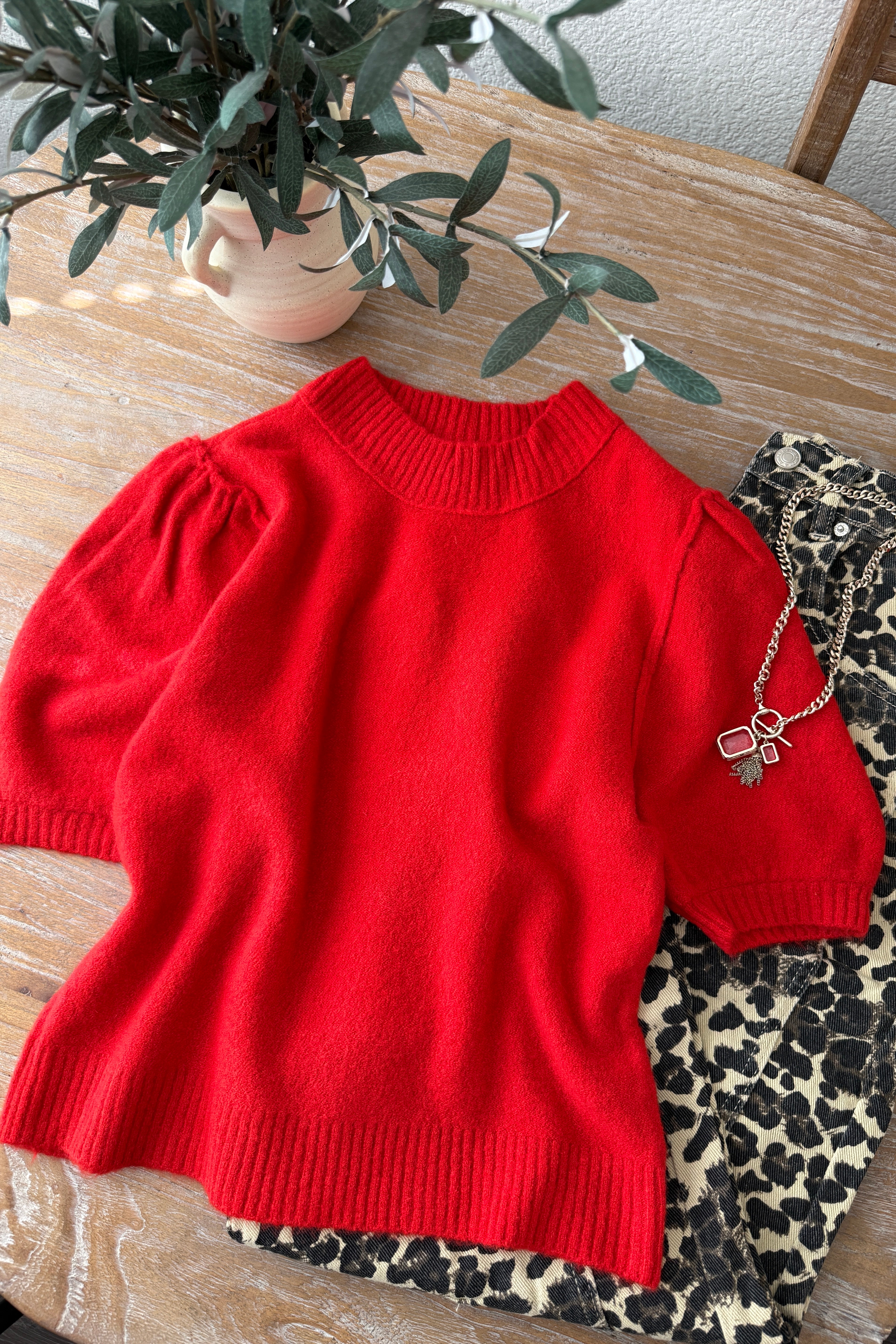 flat lay of the red balloon sleeve short sleeve sweater highlighting the crew neckline and hem