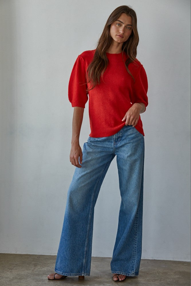 Full-body front view of the red short sleeve balloon sleeve sweater styled with blue jeans