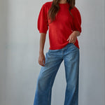 Full-body front view of the red short sleeve balloon sleeve sweater styled with blue jeans
