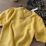 Flat lay of the yellow short sleeve balloon sleeve sweater showing knit texture and sleeves