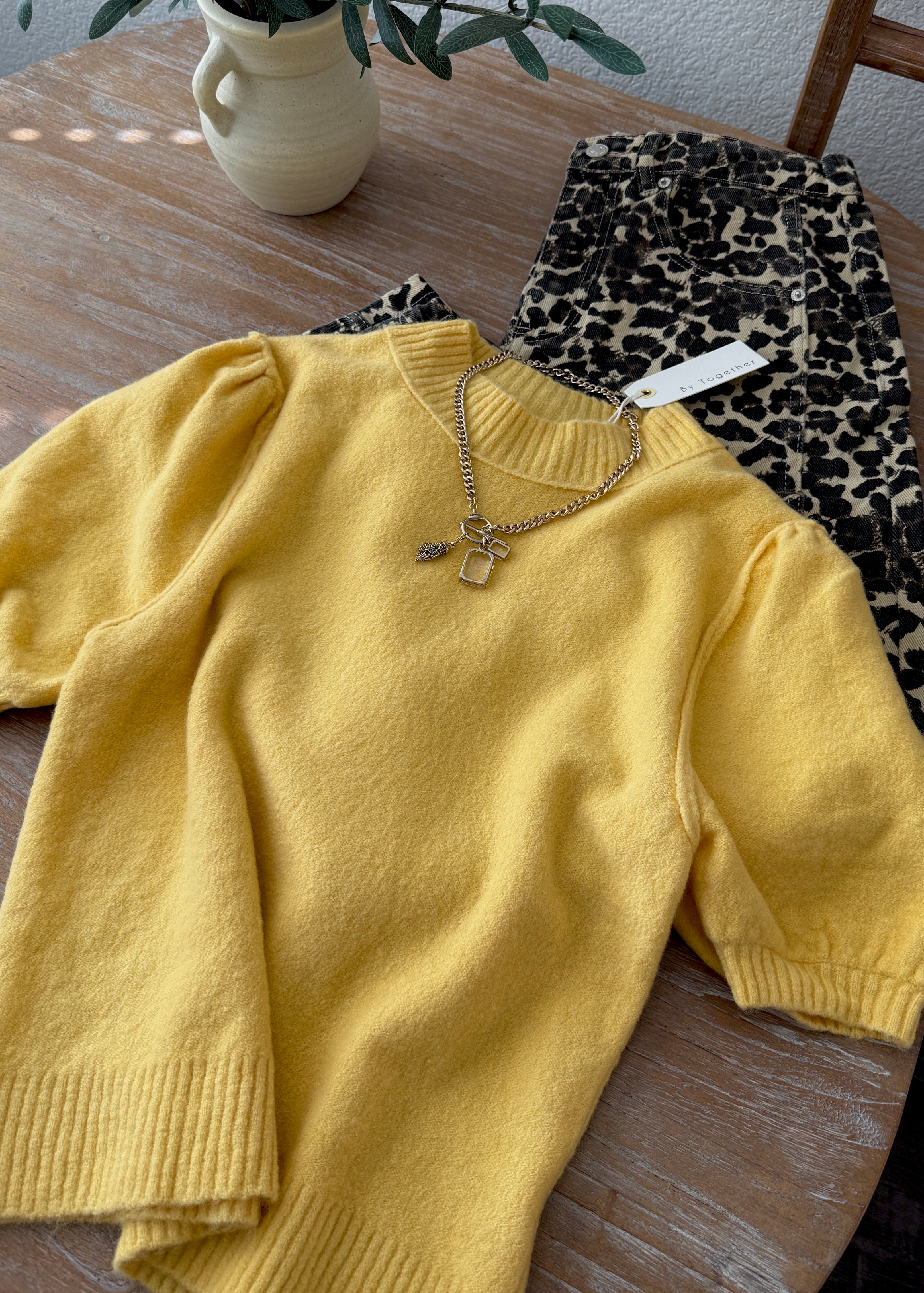 Flat lay of the yellow short sleeve balloon sleeve sweater showing knit texture and sleeves