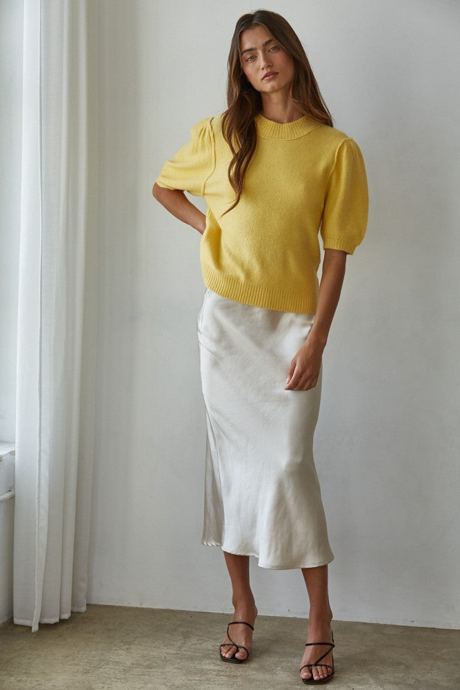 Full-body front view of the yellow balloon sleeve short sleeve sweater styled with white pants