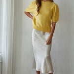 Full-body front view of the yellow balloon sleeve short sleeve sweater styled with white pants