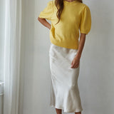 Full-body front view of the yellow balloon sleeve short sleeve sweater styled with white pants
