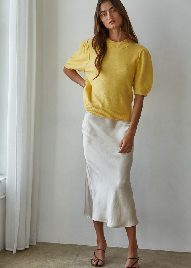 Full-body front view of the yellow balloon sleeve short sleeve sweater styled with white pants