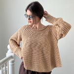 Woman wearing beige textured boatneck sweater styled with casual outfit and relaxed silhouette