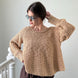 Woman wearing beige textured boatneck sweater styled with casual outfit and relaxed silhouette