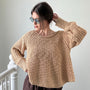 Woman wearing beige textured boatneck sweater styled with casual outfit and relaxed silhouette