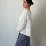 Side view of cream textured boatneck sweater with loose knit and relaxed fit