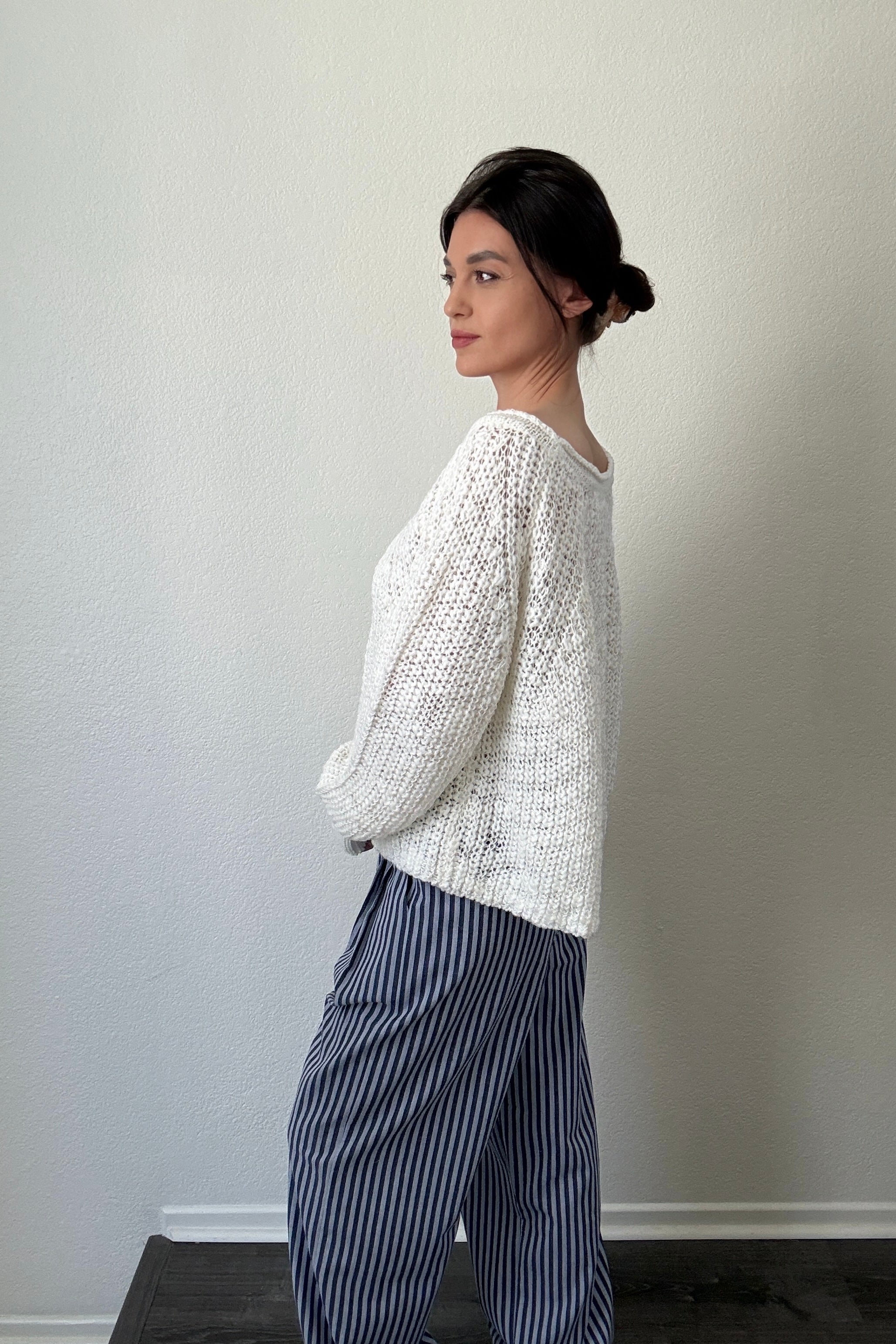 Side view of cream textured boatneck sweater with loose knit and relaxed fit