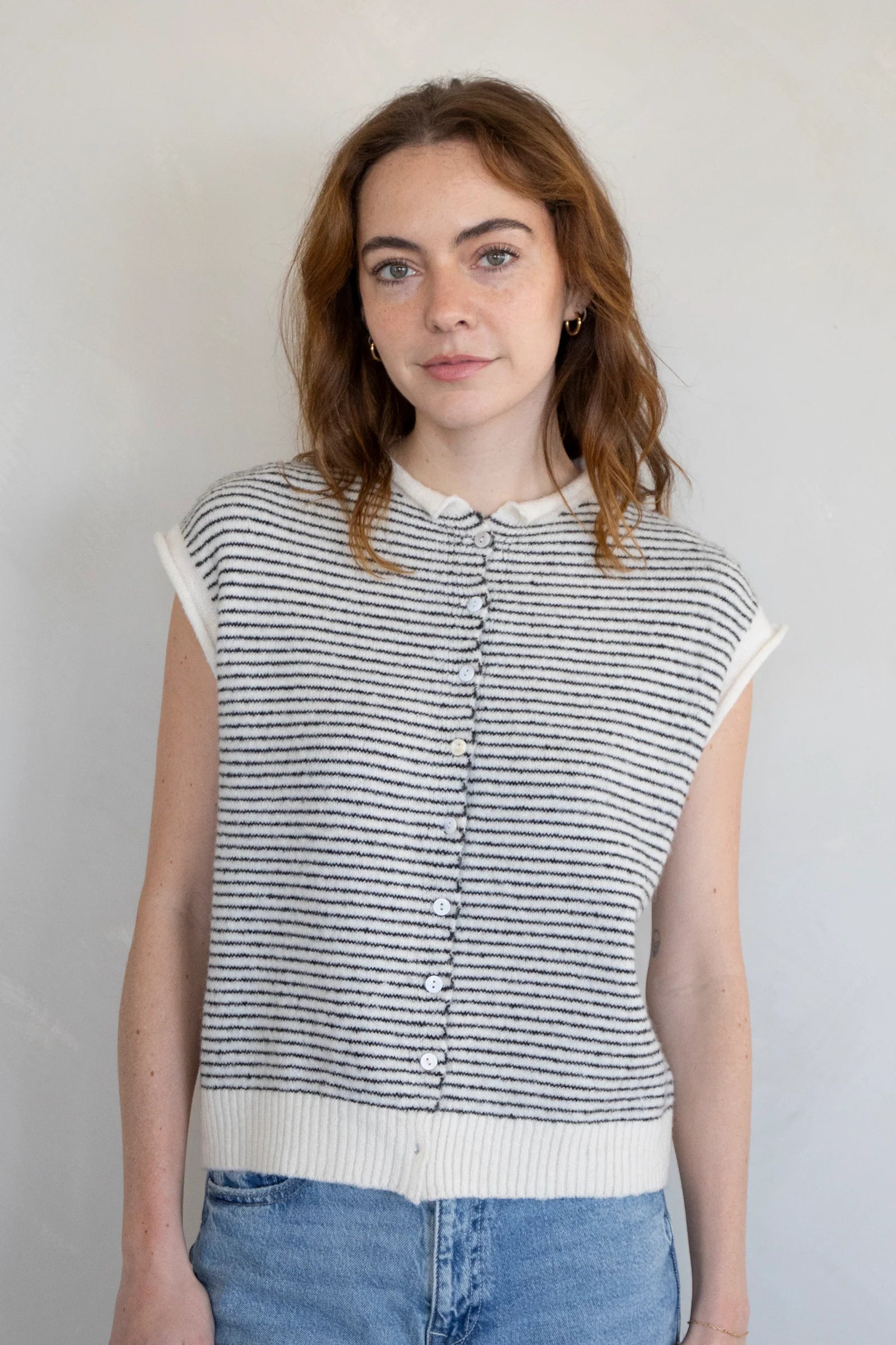 Woman wearing a striped sleeveless Piper Vest Cardigan against a plain background