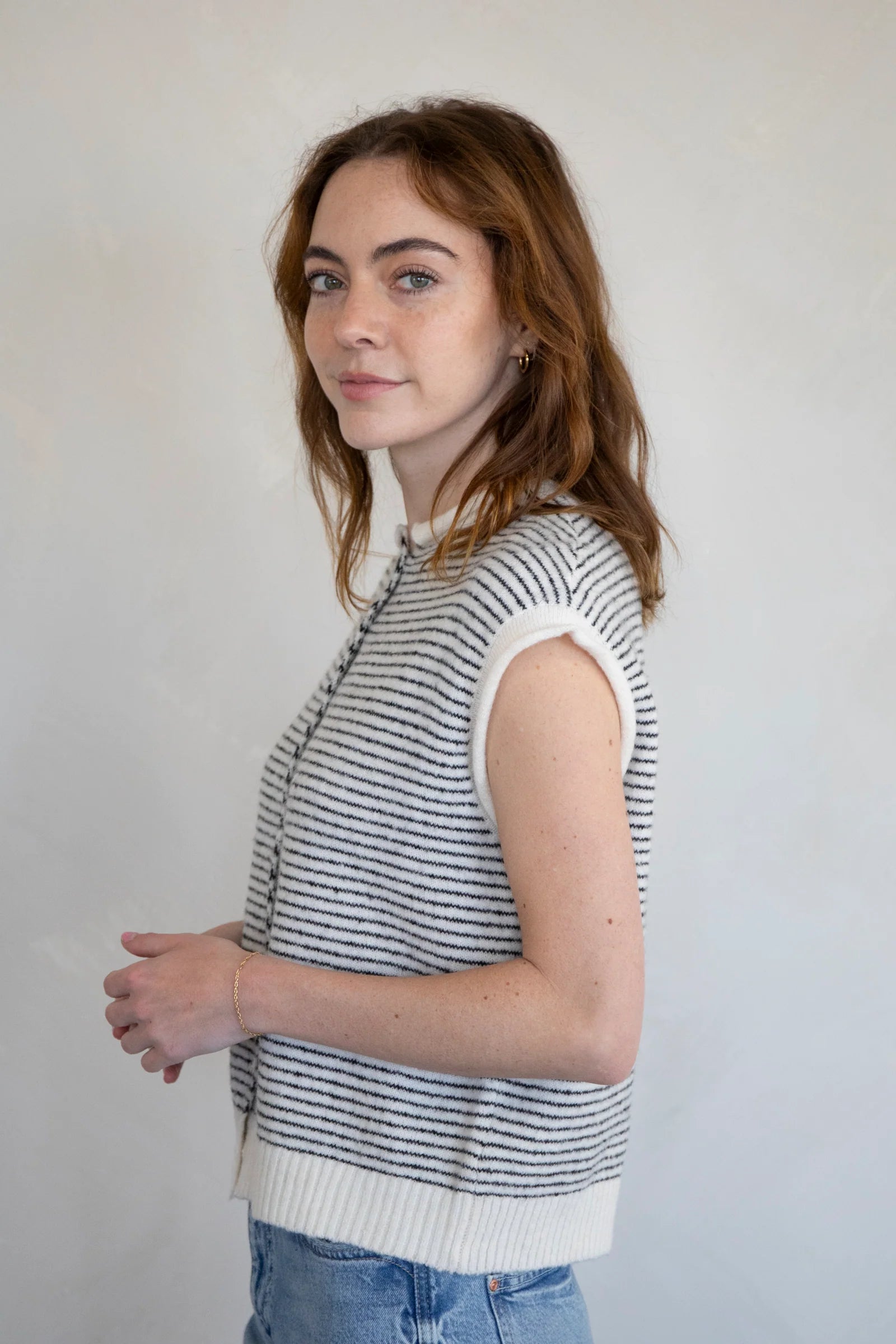 Woman wearing a sleeveless striped Hailey Piper Vest Cardigan  against a plain background