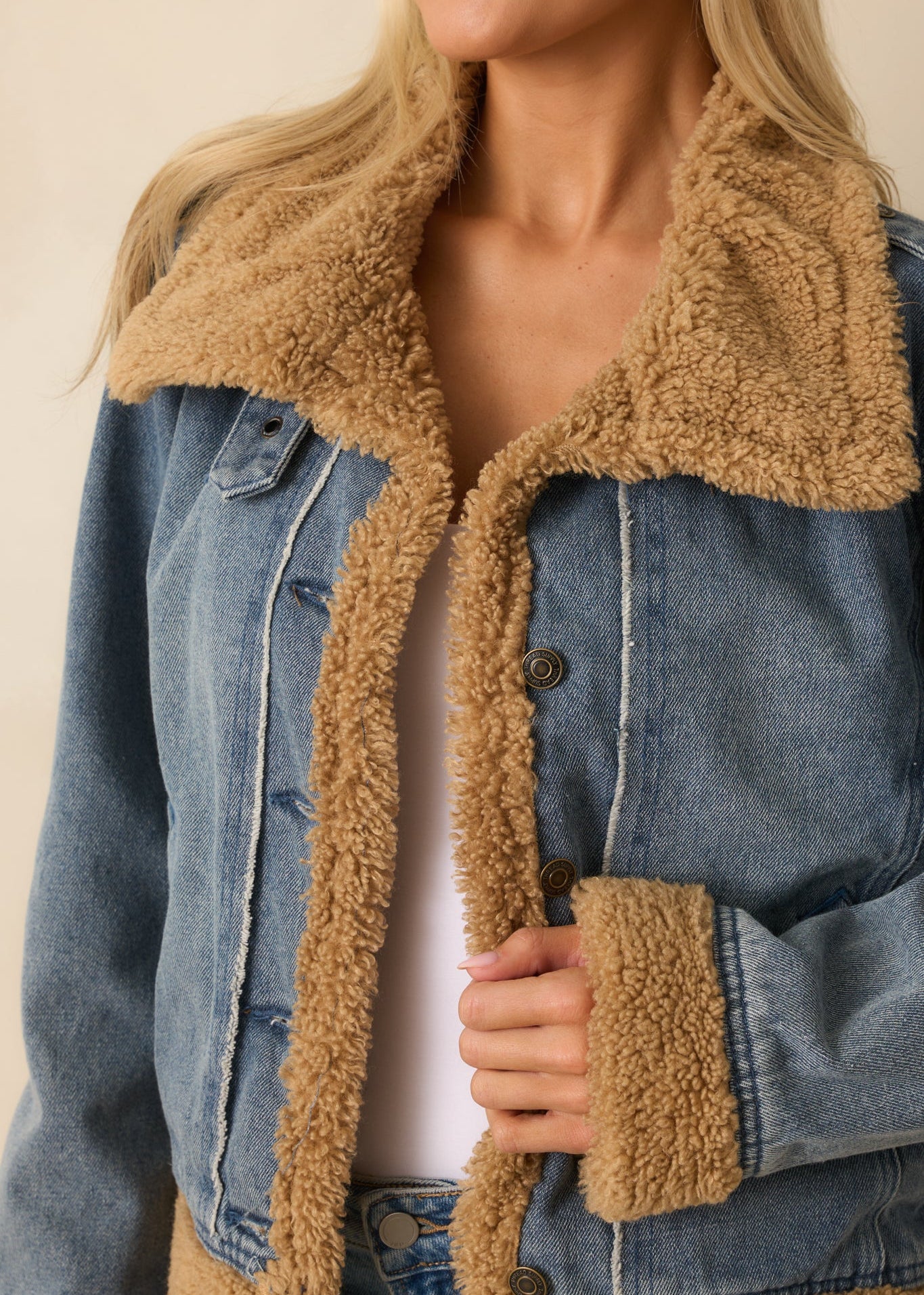 Close-up of sherpa collar and denim texture on teddy-lined jacket — warm and stylish women’s outerwear.