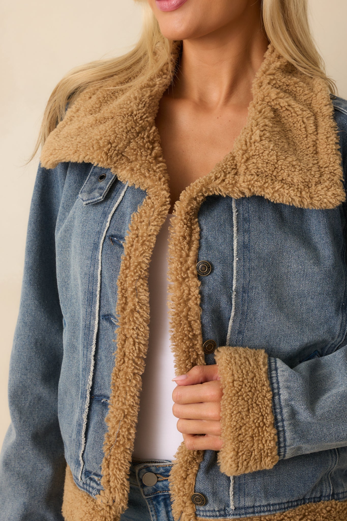Close-up of sherpa collar and denim texture on teddy-lined jacket — warm and stylish women’s outerwear.