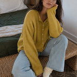 Things Between Piper Cardigan in Dijon Yellow styled with light-wash jeans for a casual indoor outfit