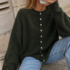 Woman wearing the Things Between Piper Cardigan in dark hunter green
