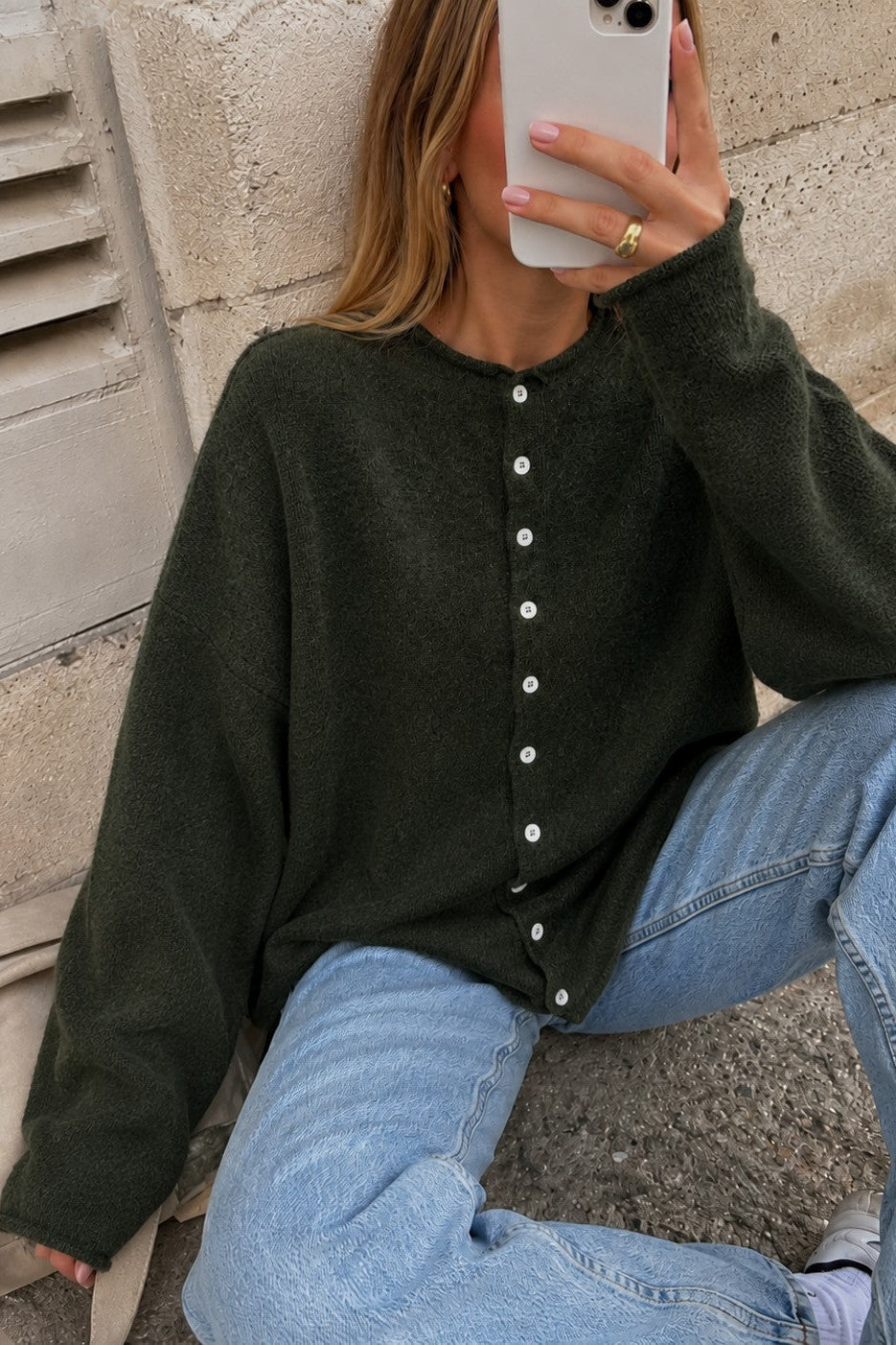 Woman wearing the Things Between Piper Cardigan in dark hunter green