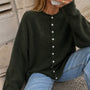 Woman wearing the Things Between Piper Cardigan in dark hunter green