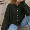 Woman wearing the Things Between Piper Cardigan in dark hunter green