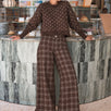Woman wearing Trudy chocolate plaid wide-leg pants inside a coffee shop