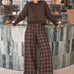 Woman wearing Trudy chocolate plaid wide-leg pants inside a coffee shop