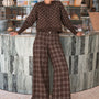 Woman wearing Trudy chocolate plaid wide-leg pants inside a coffee shop