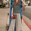 Woman wearing Trudy grey plaid wide-leg pants with a sweater and flats