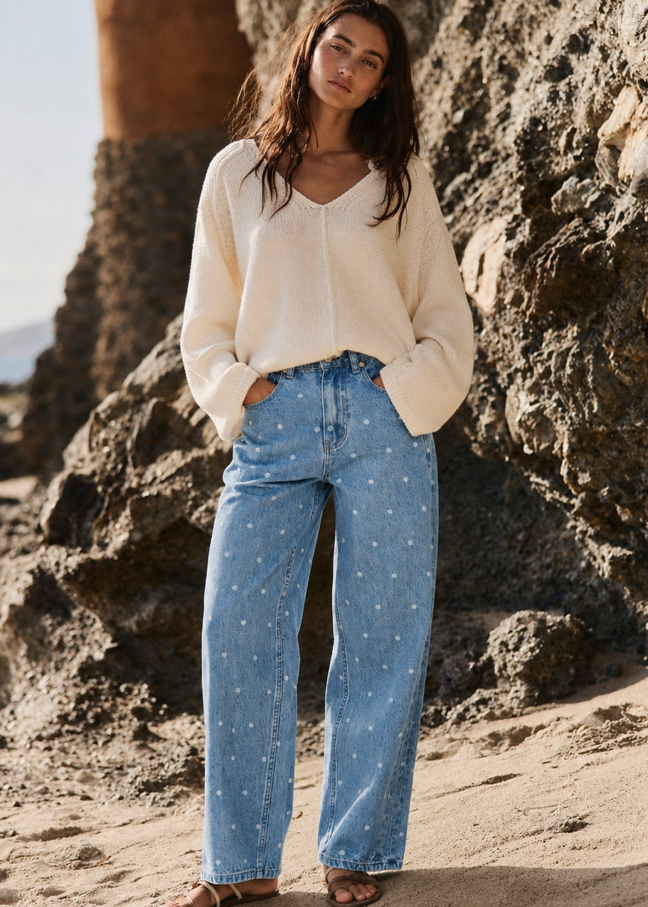 Woman wearing Truro High Rise Barrel Jeans in Denim Polka Dot in a beach lifestyle photo