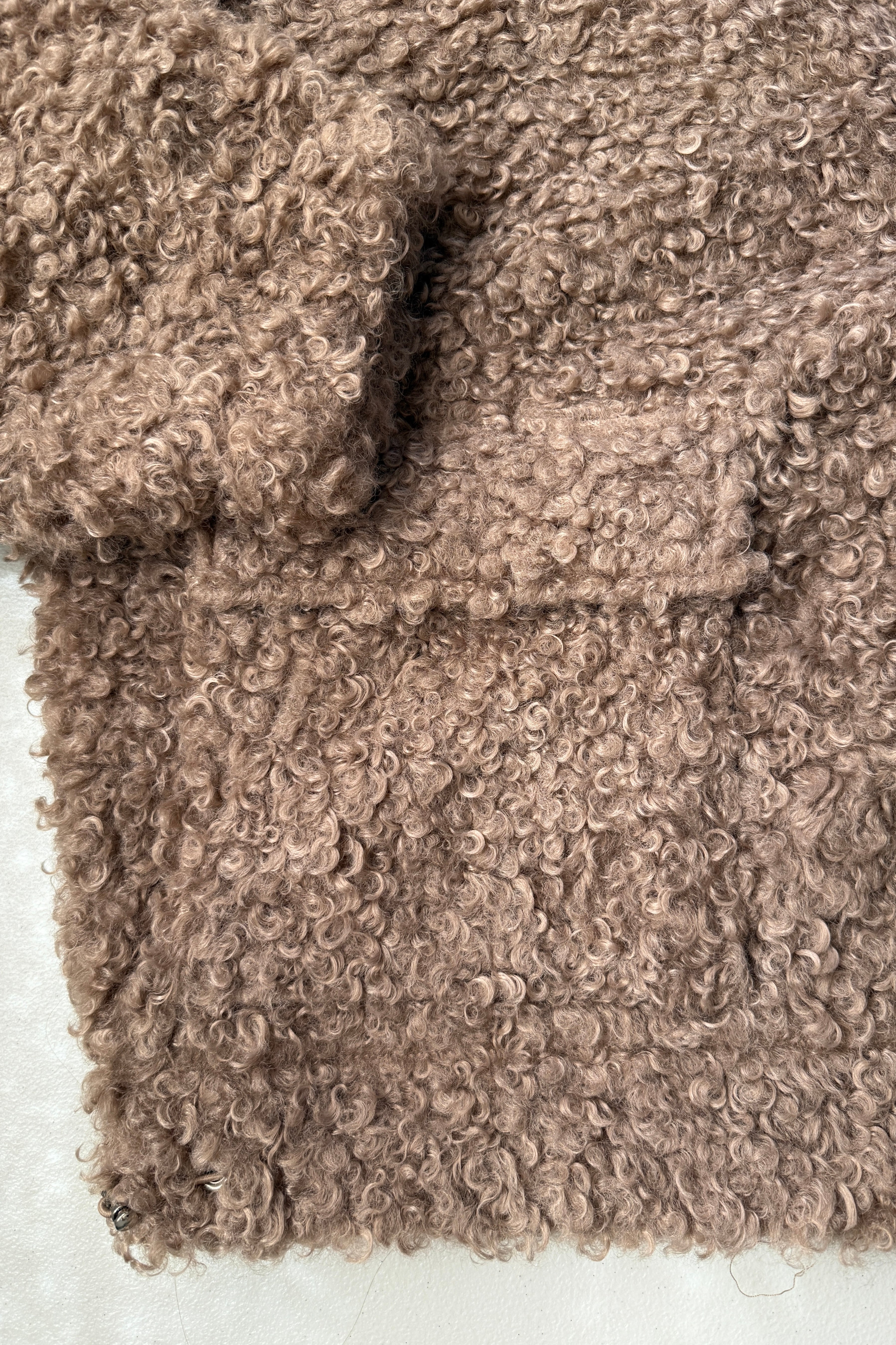 Close-up of plush teddy fabric texture on ultra soft jacket in taupe