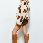 Side view of the cow print faux fur jacket showing oversized fit