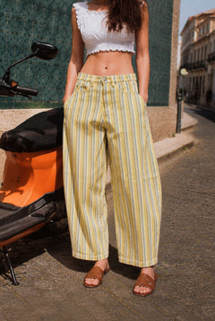 Model wearing Aaron & Amber striped barrel pants in Yellow with a white cropped top