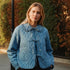 Woman wearing Chloe Bow Quilted Denim Jacket in denim with quilted texture, bow tie closure, and lace Peter Pan collar