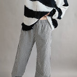 Angled front view of Wanderlust gingham boxer pants in black