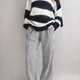 Model is wearing Wanderlust gingham boxer pants in black with elastic waistband and relaxed fit