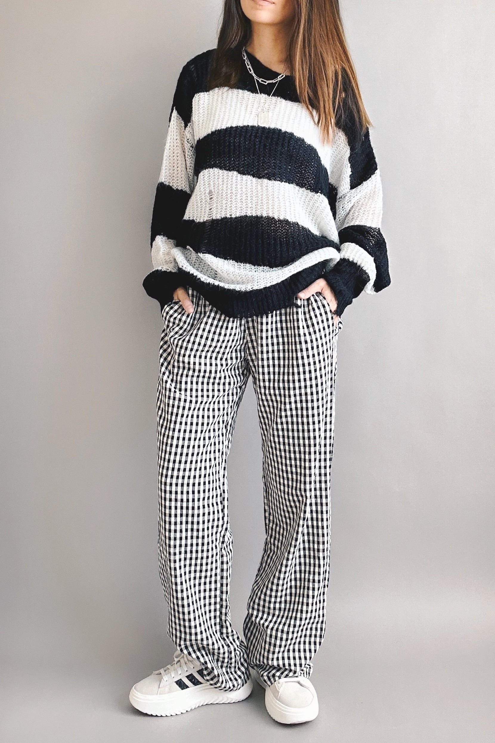 Model is wearing Wanderlust gingham boxer pants in black with elastic waistband and relaxed fit