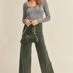 Model is wearing Wild Honey straight wide leg denim pants in washed black with high-rise fit