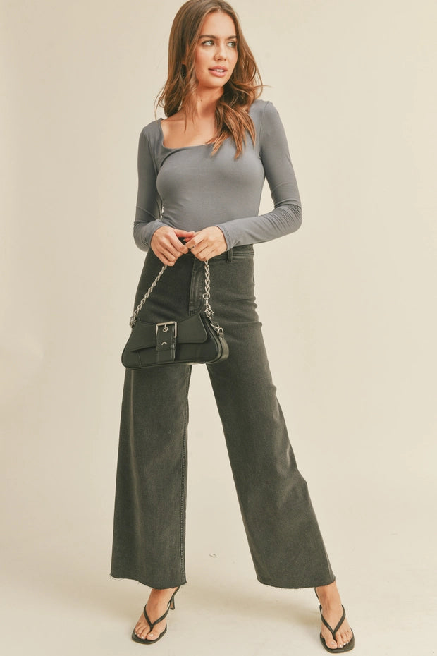 Model is wearing Wild Honey straight wide leg denim pants in washed black with high-rise fit