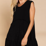 Angled front view of Wildest Rose black tunic dress showing flowy ruffle hem