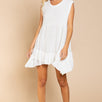 Model is wearing Wildest Rose tunic dress in off white with baby doll silhouette and ruffle hem