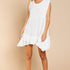 Model is wearing Wildest Rose tunic dress in off white with baby doll silhouette and ruffle hem