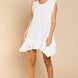 Model is wearing Wildest Rose tunic dress in off white with baby doll silhouette and ruffle hem