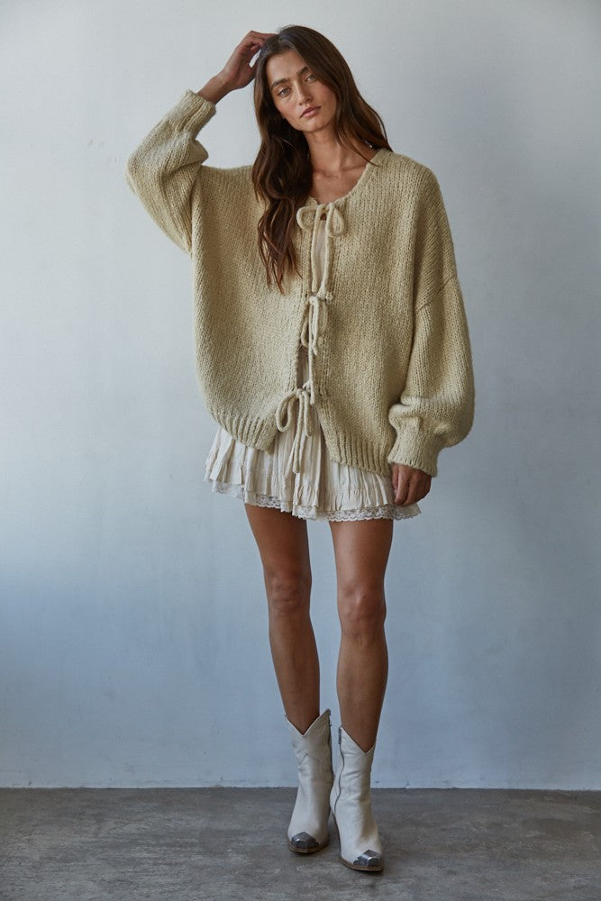 Woman wearing the Willow Boho Tie Cardigan, also known as the Sadie Tie Front Cardigan, in light taupe — soft boho knit with tie-front closure and scoop neckline.