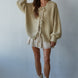 Woman wearing the Willow Boho Tie Cardigan, also known as the Sadie Tie Front Cardigan, in light taupe — soft boho knit with tie-front closure and scoop neckline.