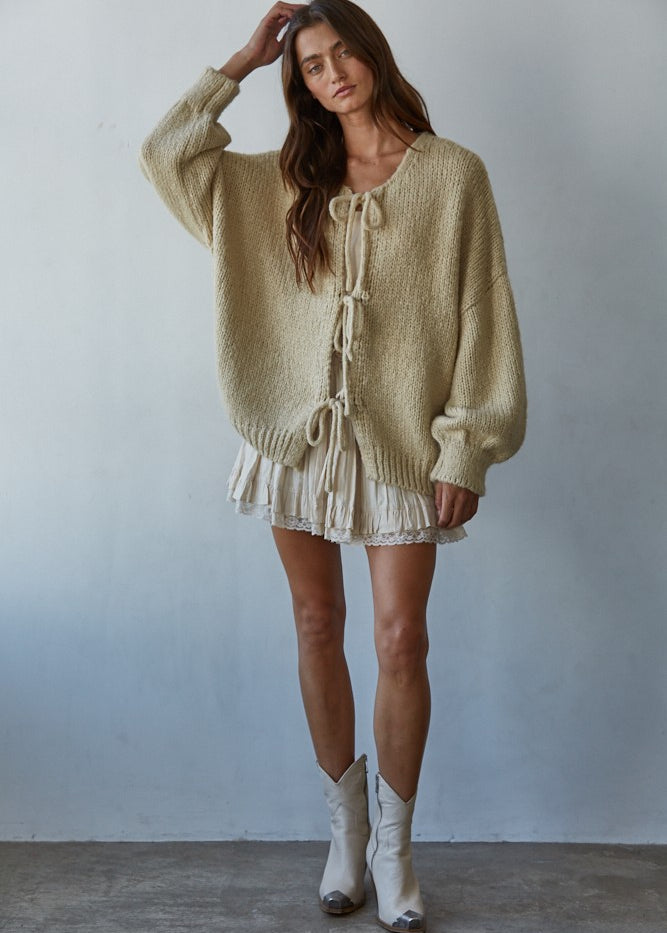 Woman wearing the Willow Boho Tie Cardigan, also known as the Sadie Tie Front Cardigan, in light taupe — soft boho knit with tie-front closure and scoop neckline.
