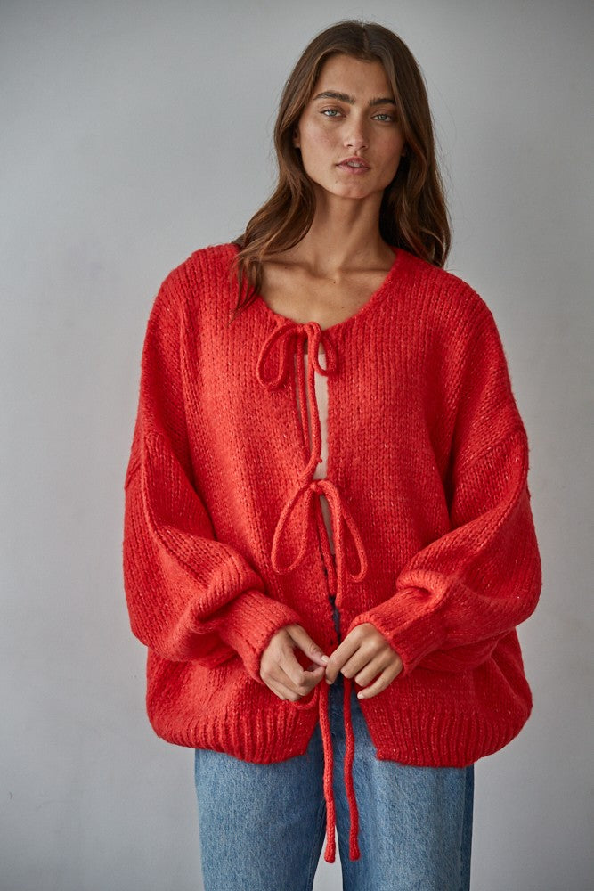 Woman wearing the Willow Boho Tie Cardigan, also known as the Sadie Tie Front Cardigan, in red — soft boho knit with tie-front closure and scoop neckline.