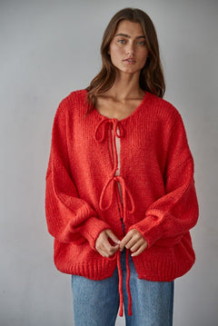Woman wearing the Willow Boho Tie Cardigan, also known as the Sadie Tie Front Cardigan, in red — soft boho knit with tie-front closure and scoop neckline.